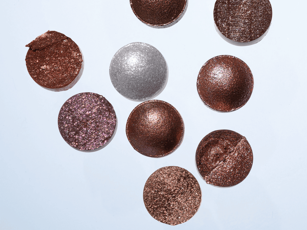 Close-up of metallic eyeshadow gathered in the natural fold of a closed eyelid.  