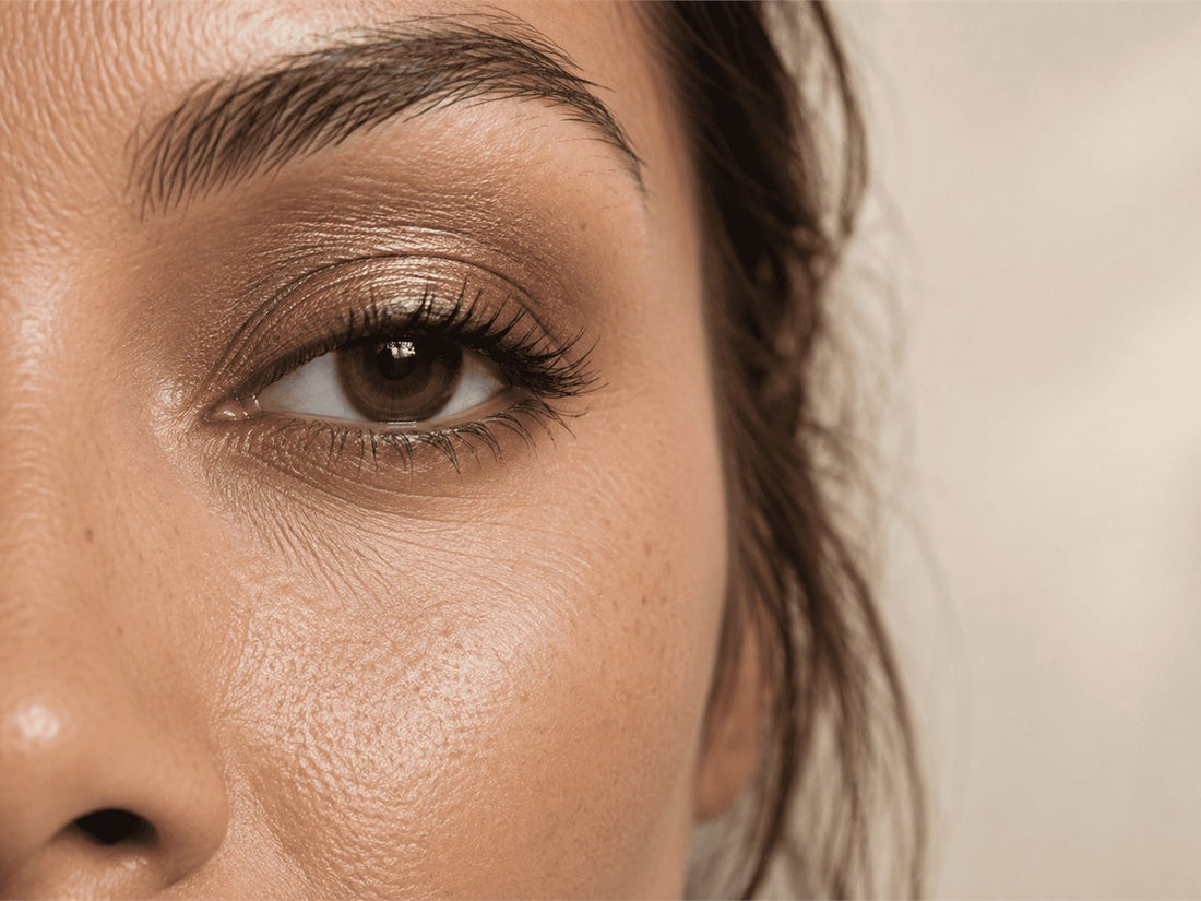 Close-up of bronze metallic eyeshadow on an eyelid with the under-eye area visible.